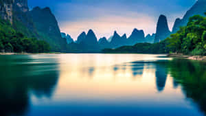 喀斯特山峰倒映在暮色中的平靜河流