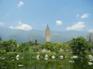 三座塔倒映在池塘中，背景有山。 — 廟宇 壁紙