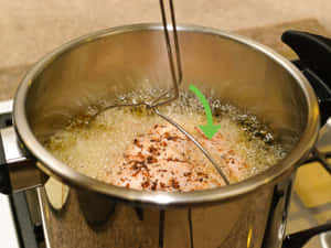 調味雞肉在爐灶上的金屬鍋中油炸。 — 4:3 壁紙