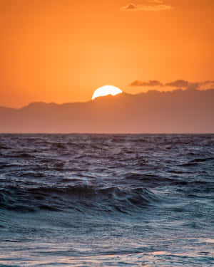 海洋上的夕陽，遠方有山