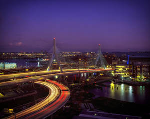 黃昏時分，水面上閃爍的橋樑，城市中汽車燈光劃過。 — 夜景城市 壁紙