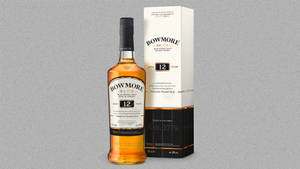 灰色背景上的 Bowmore 12 年威士忌酒瓶和盒子