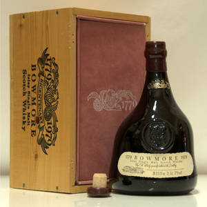 一瓶復古 Bowmore 威士忌，附有木盒和軟木塞，置於反光表面上。
