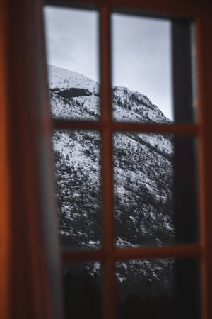 透過木質窗戶看到的雪覆蓋的山。 — 黑白藝術 壁紙