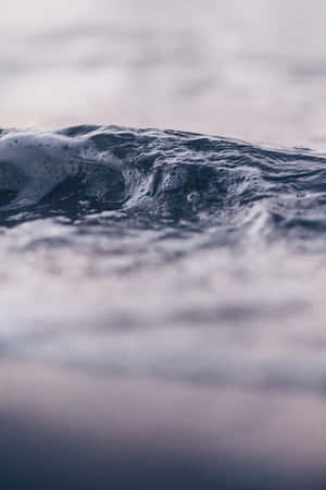 海浪特寫，白色泡沫在平靜的海水中翻滾。