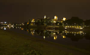 城堡倒映在河中的夜景，伴有燈光小徑。