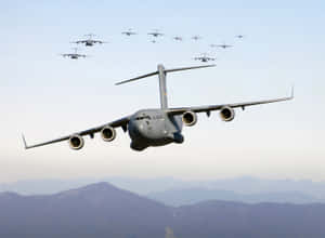 軍用運輸機在山脈上空編隊飛行