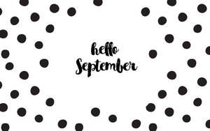 黑色圓點圍繞著白色背景上手寫的「hello September」。