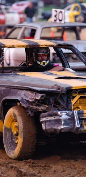 破爛的 demolition derby 賽車，車手戴著頭盔，在泥濘賽道上。
