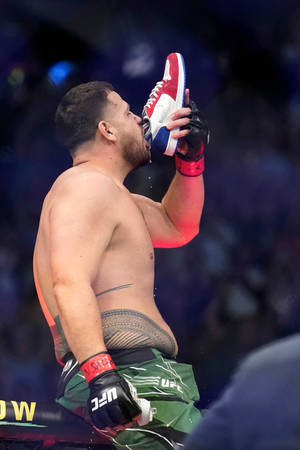 MMA拳手在八角籠中獲勝後從運動鞋中飲水。 — Huawei MatePad Edge 壁紙