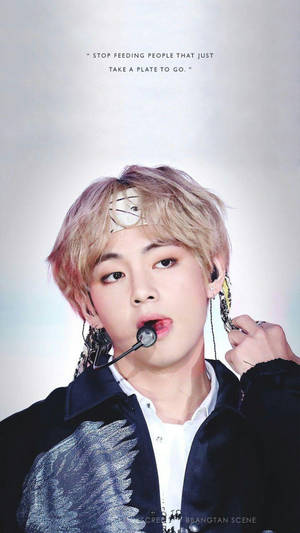 K-pop 藝人手持咪高峰及穿著羽毛外套表演。
