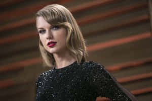 Taylor Swift 身穿黑色亮片連衣裙，塗著紅色唇膏在室內擺姿勢。