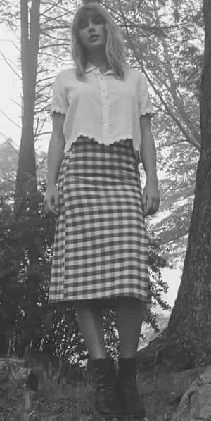 穿格仔裙的女士穿著靴子站在森林中