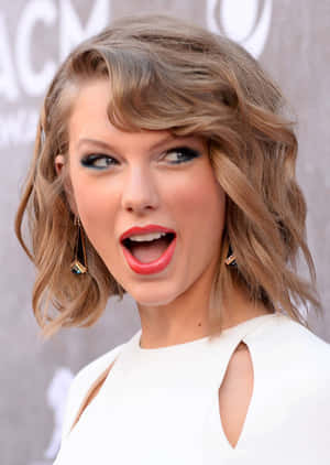 Taylor Swift 在活動中留著波浪金髮和塗著紅色唇膏。