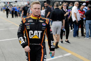 NASCAR車手Tyler Reddick身穿CAT賽車服在賽道上行走。