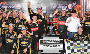 NASCAR Cup Series 車隊手持獎盃和方格旗慶祝勝利。