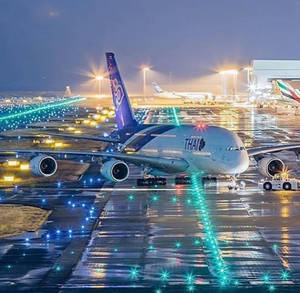 泰國航空A380在夜間濕滑跑道上，發光藍色燈光在水坑中反射。 — 飛機 壁紙
