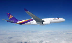 泰國航空飛機在清澈藍天的雲層上方飛行