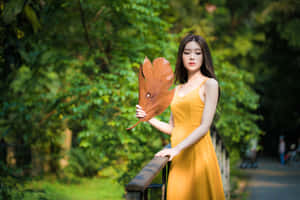 黃裙女性在綠色公園手持大葉