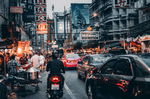 黃昏時繁忙的城市街道，汽車、電單車和行人在霓虹燈下。 — 唐人街 GIF 壁紙