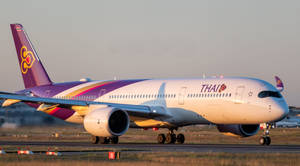 泰國航空飛機在黃金時段日落時分的跑道上
