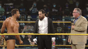 WWE NXT摔角手和評論員在擂台上，觀眾戴著面具。