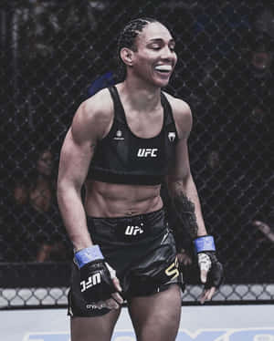 女性MMA拳手在UFC八角籠中以燦爛笑容慶祝勝利。