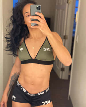 穿著UFC裝備的女性在室內對著鏡子自拍