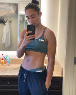 穿著運動服的健美女性在浴室中對著鏡子自拍。