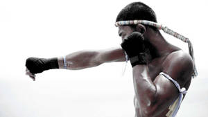 一位穿著傳統裝備的泰拳拳手打出一拳。