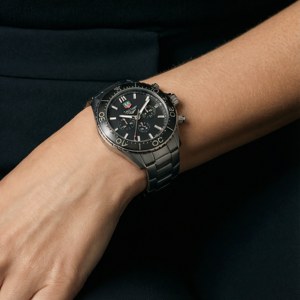 一隻黑色Tag Heuer計時碼錶戴在人的手腕上。
