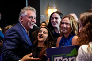 一位政治家在競選集會上與微笑的支持者一起大笑。