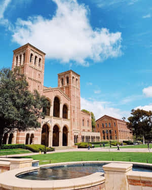 大學校園，有紅磚建築、綠色草坪和噴泉，在陽光明媚的天空下。