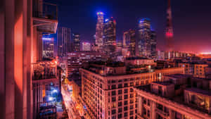 繁華城市的夜景，有明亮的摩天大樓和發光的街道。 — 日落大道 壁紙