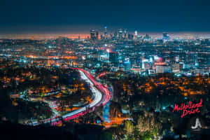 城市夜景，有明亮的燈光和彎曲道路上移動的汽車。