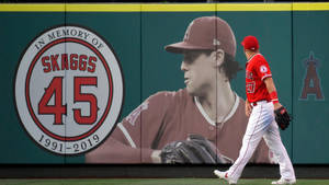 棒球運動員走過紀念投手Skaggs 45號的壁畫。
