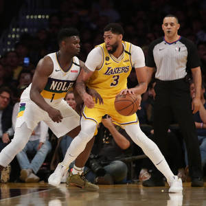 湖人球員喺NBA比賽中運球對抗鵜鶘防守球員，附近有裁判。