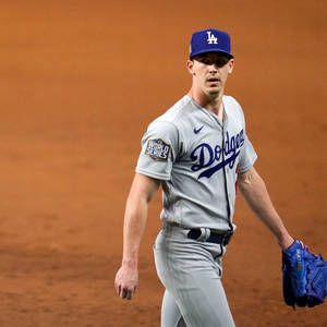 身穿道奇球衣的棒球選手在夜間走在泥地球場上。 — 棒球 壁紙