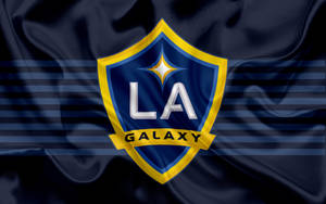 LA Galaxy 足球隊標誌在帶有條紋的深藍色緞面旗幟上。 — 足球 壁紙