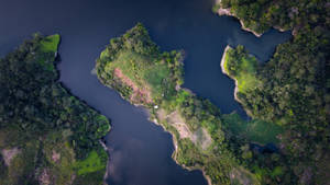俯瞰藍色湖泊中森林覆蓋的島嶼，帶有小型人類建築。