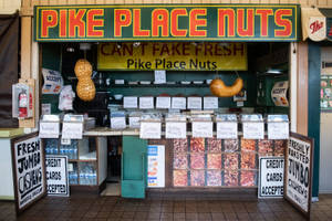 Pike Place堅果市場攤位，玻璃容器裝著烤堅果和懸掛的花生。