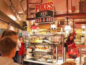 顧客在 Pikes Pit BBQ 餐廳玻璃後觀看煙燻肉類。