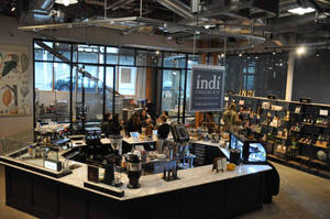 Indi Chocolate 咖啡館和工廠內部，顧客和員工在櫃檯後方。