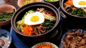 石鍋中冒著蒸氣的韓國拌飯，配雞蛋和蔬菜。 — 清新 GIF 壁紙