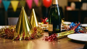 節日餐桌，配有香檳瓶、派對帽和閃粉，用於慶祝。 — 新年動畫 壁紙