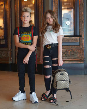 兩位穿著Gucci街頭服的青少年在室內華麗門附近擺姿勢。