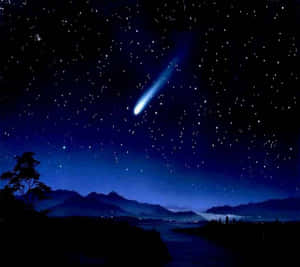 一顆明亮的藍色彗星在佈滿星星的夜空中拖著尾巴，越過山脈剪影。 — 星星 壁紙