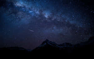 積雪的山峰在星空下，有銀河和流星。 — 夜空 壁紙