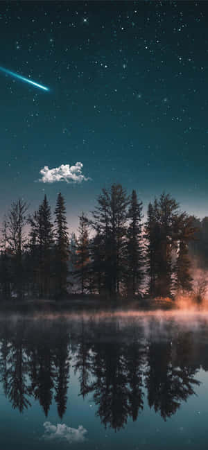 在流星劃過的星空下，霧濛濛的湖面倒映著森林樹木和天空。