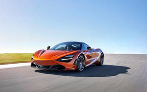 橙色McLaren 720S在日落時分的沙漠公路上飛馳。 — 4K 法拉利 壁紙